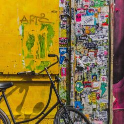 bike parked beside wall full of stickers